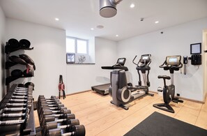 A gym with exercise equipment, a treadmill, an elliptical, and a stationary bike.