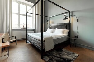 Un dormitorio moderno con una cama con dosel, un escritorio y una silla.