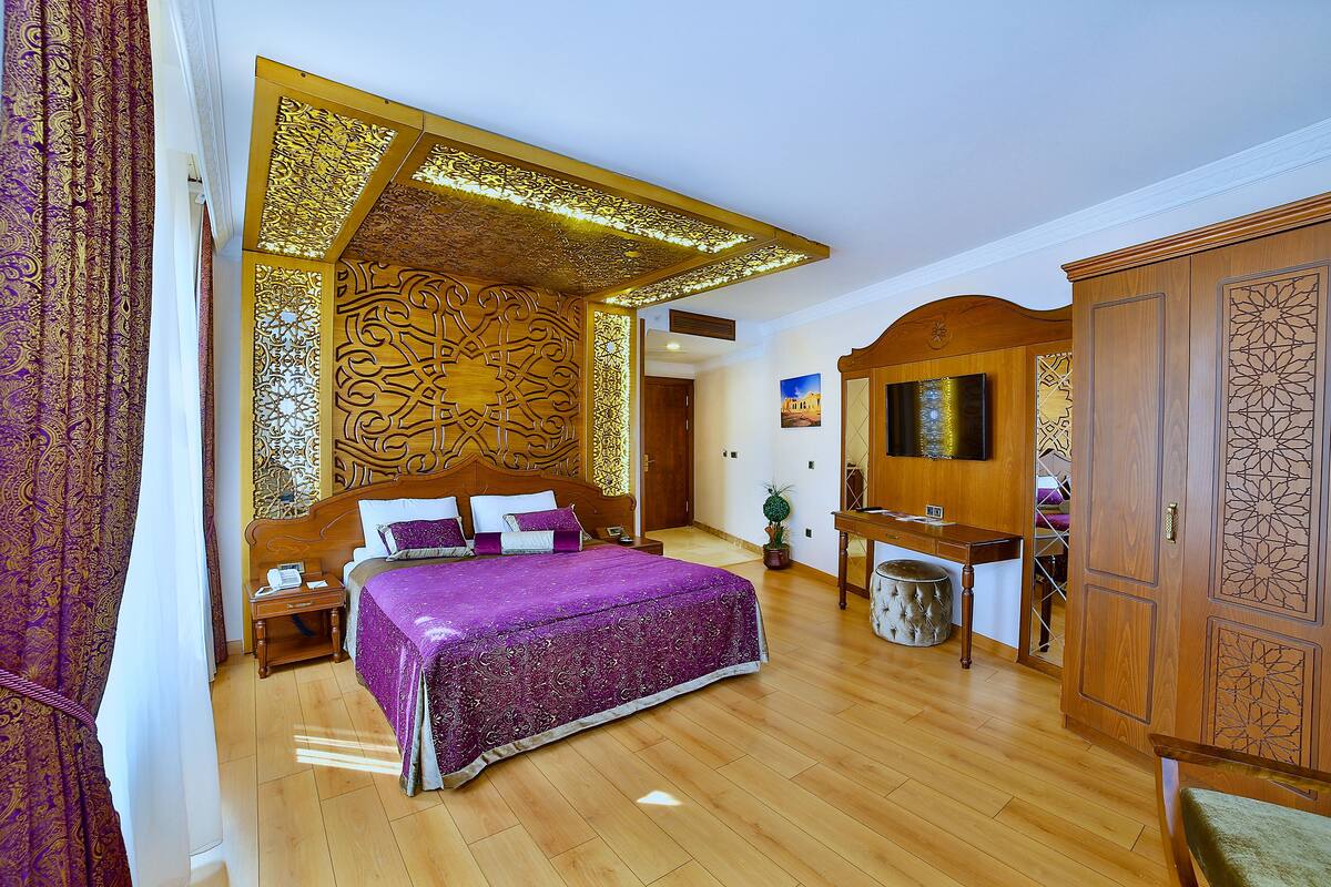 Un dormitorio con una cama grande, cabecera de madera y paneles decorativos.