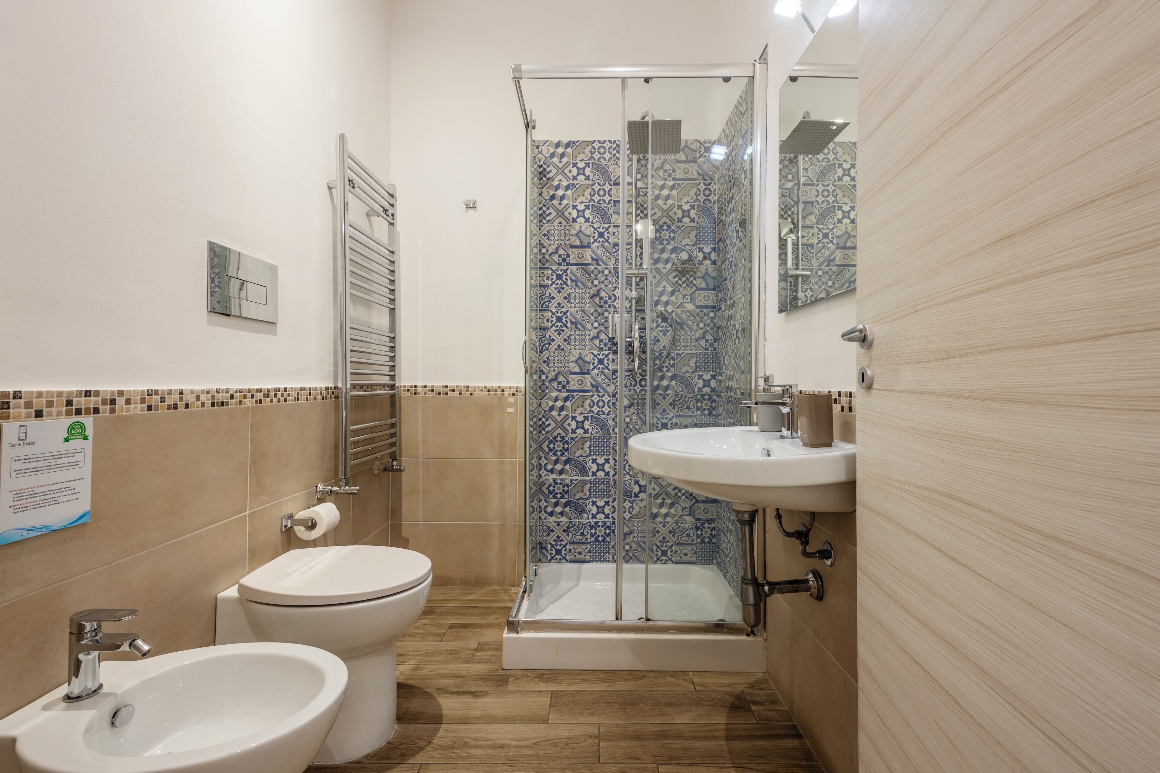 A bathroom with a toilet, bidet, sink, and shower.