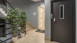 A modern interior with a staircase, potted plants, a door, and a sign indicating a stable room. - Quinto Stabile Rooms&Suite (Palermo)