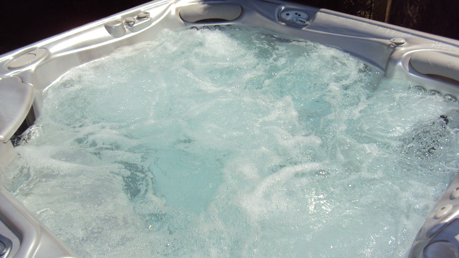 A hot tub with visible bubbles and water jets, indicating active use.