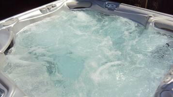 A hot tub with visible bubbles and water jets, indicating active use.