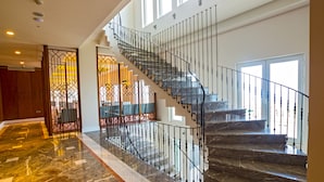 A spacious interior with a marble staircase, a view of the outdoors through large windows, and a modern design. - Mell Hotel (Trabzon)