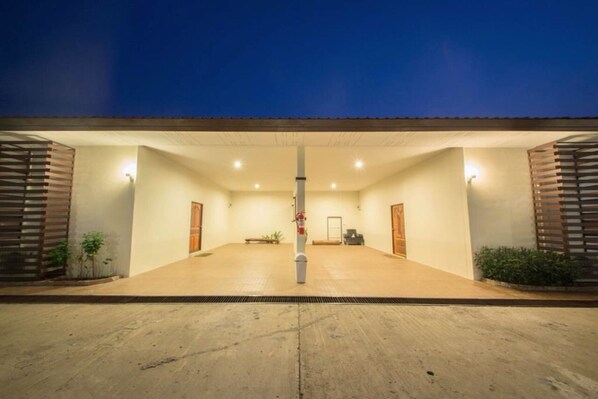 A spacious indoor area with a central pole, two doors, and a bench.