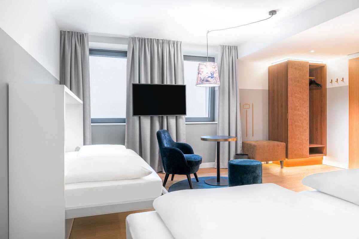 Een moderne hotelkamer met een groot bed, een klein bureau, een stoel en een televisie.