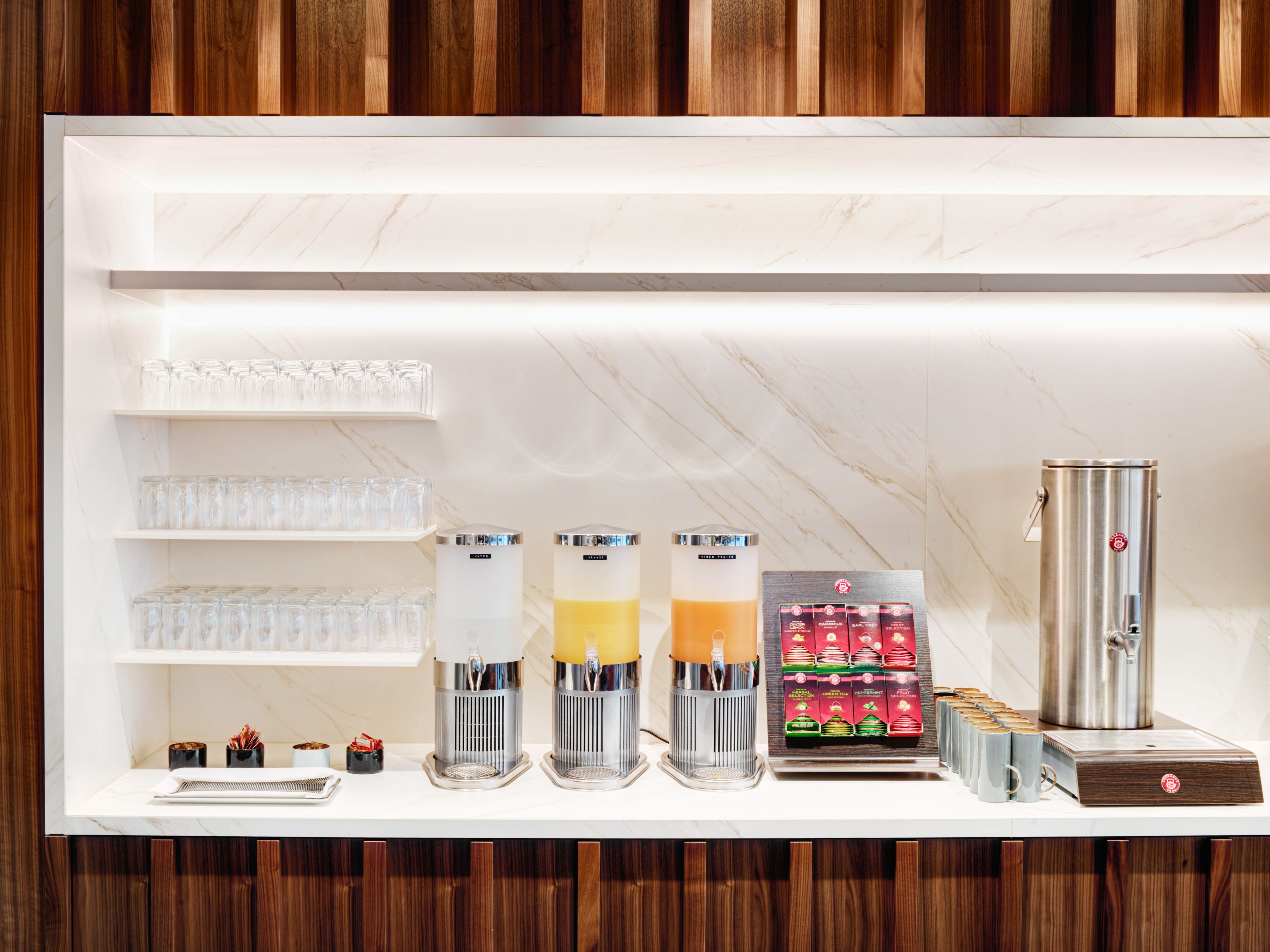 Eine moderne Bar mit Marmorplatte, Gläsern und einer Kaffeemaschine.