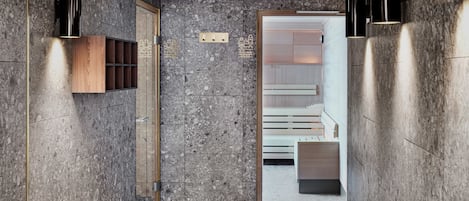 A modern hallway with marble walls, built-in wooden shelving, and black wall sconces.