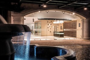 A modern hotel entrance with a water feature in the foreground, a glass facade, and a minimalist interior design. - AC Hotel by Marriott Guatemala City (Guatemala City)