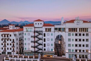 Ein Hotel mit mehreren Etagen, einer zentralen Treppe und Blick auf Berge im Hintergrund.
