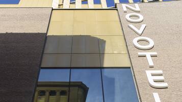 A hotel with a modern facade, large windows, and a prominent 'NOVOTEL' sign.
