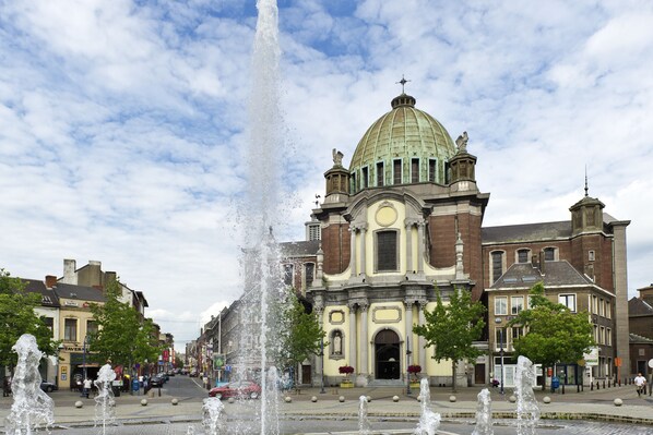 A historic building with a prominent dome and a central fountain.