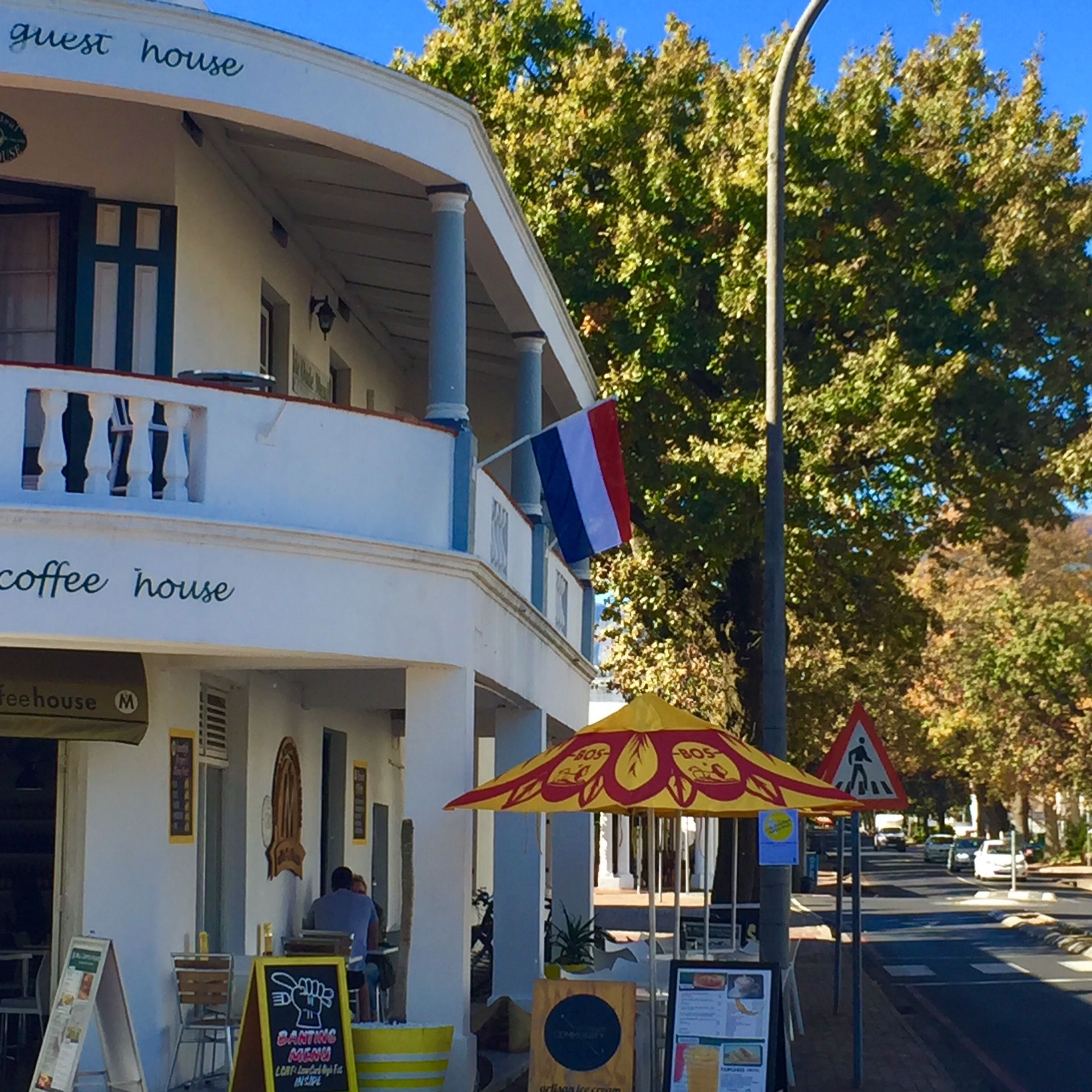 A building with a balcony and a sign that reads "guest house".