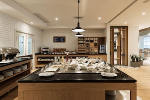 A modern kitchen area with a buffet setup, a coffee machine, and a menu board.