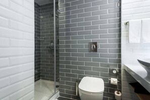A bathroom with a shower, toilet, and towel rack. - Holiday Inn Express Astana - Turan (Astana)