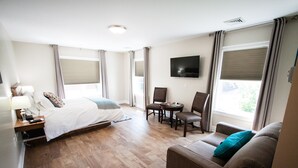 Una habitación de hotel con cama, sofá, mesa y televisor.
