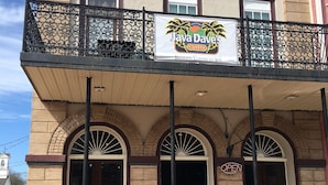Ein Gebäude mit einem Schild für 'Java Dave's Coffee' und einem Balkon mit schmiedeeisernen Geländern.