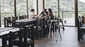 Un restaurant doté de grandes fenêtres donnant sur un paysage montagneux.