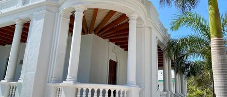 A white building with a covered porch and columns.