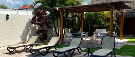 A swimming pool with lounge chairs and a pergola.