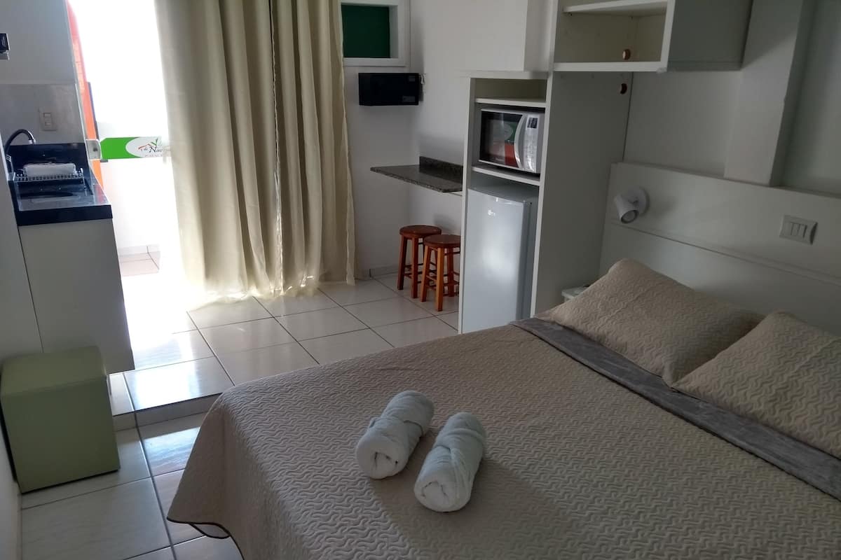 Een hotelkamer met een bed, een bureau, een magnetron en een zithoek.