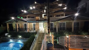 Un edificio de varios pisos con piscina y zona de estar al aire libre.