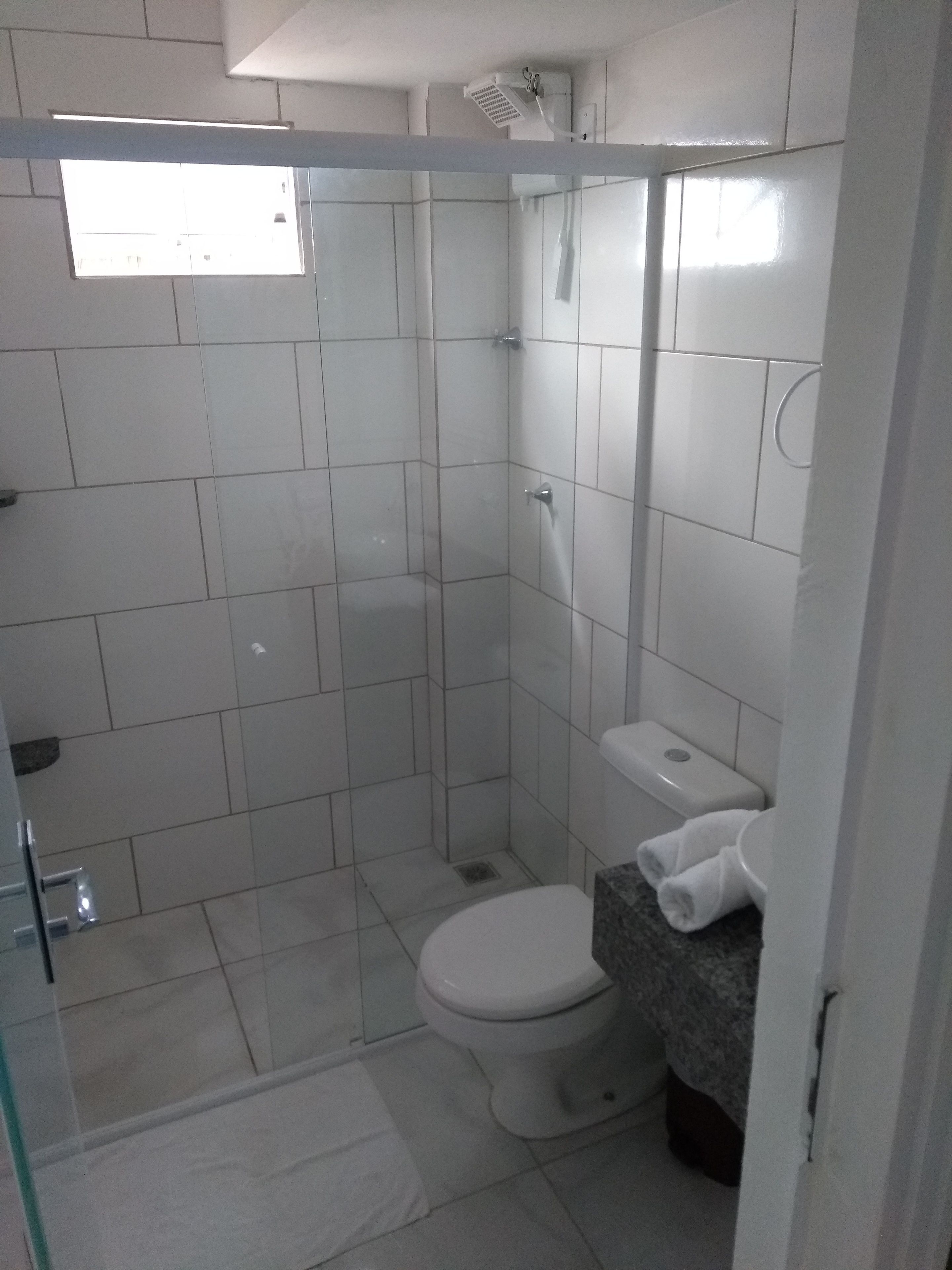 A bathroom with a shower, toilet, and sink.