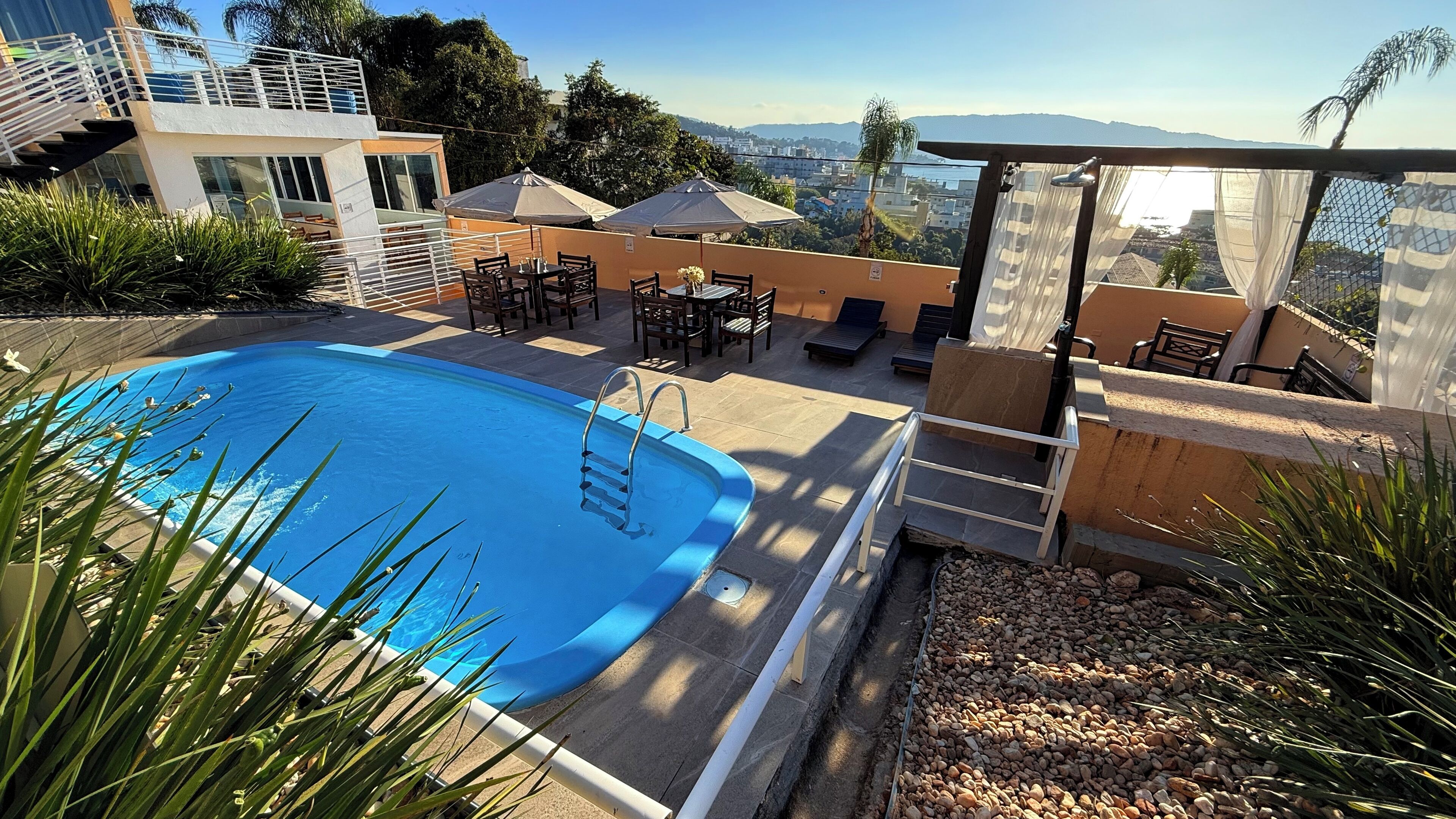 Una piscina con vistas a la ciudad y montañas al fondo.