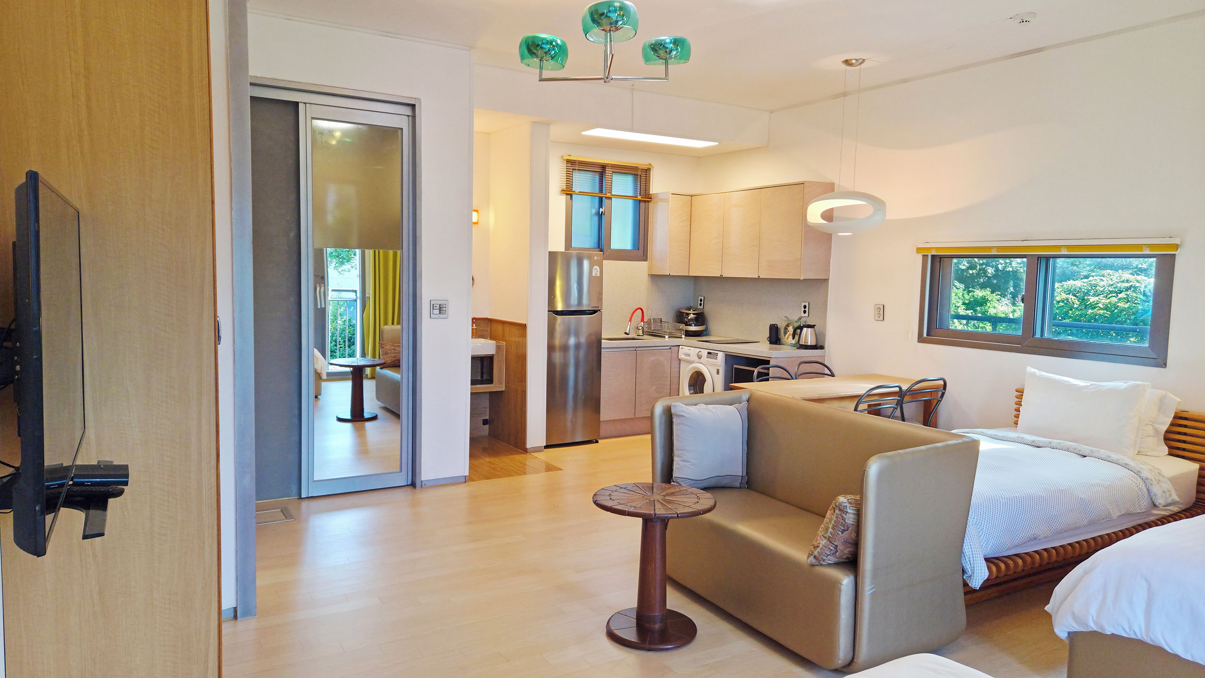 A compact living space with a kitchenette, a dining area, and a bedroom.