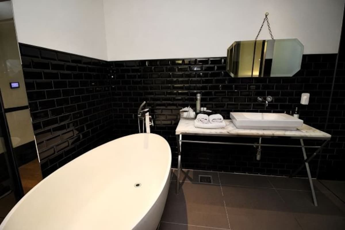 A modern bathroom with a freestanding bathtub, a vanity with a sink, and a mirror.