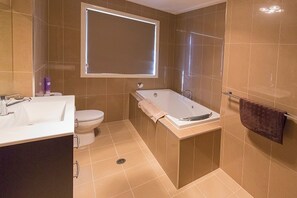 A bathroom with a bathtub, toilet, and sink. - Gold Mine Guesthouse (Nundle)