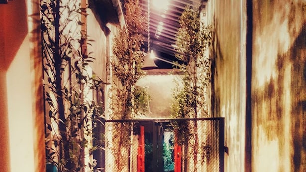 A narrow corridor with wooden flooring, metal railings, and potted plants. - The Roo Classic Hometel (Songkhla)