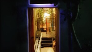 A narrow, dimly lit hallway with a staircase leading to a brightly lit room. - The Roo Classic Hometel (Songkhla)