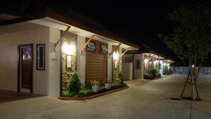 A hotel with a covered entrance, potted plants, and a well-lit facade. - Mantra Resort (Songkhla)