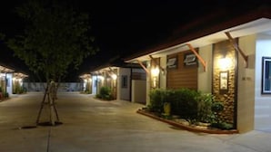 A well-lit hotel corridor with a wooden facade and a stone accent wall. - Mantra Resort (Songkhla)