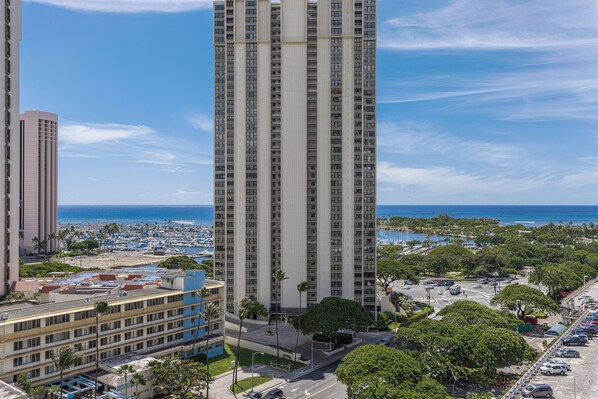 Un edificio alto con vista al océano y un puerto deportivo.