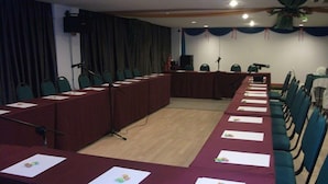 A conference room with a long table, microphones, and chairs. - Hotel KK Equine Park (Seri Kembangan)