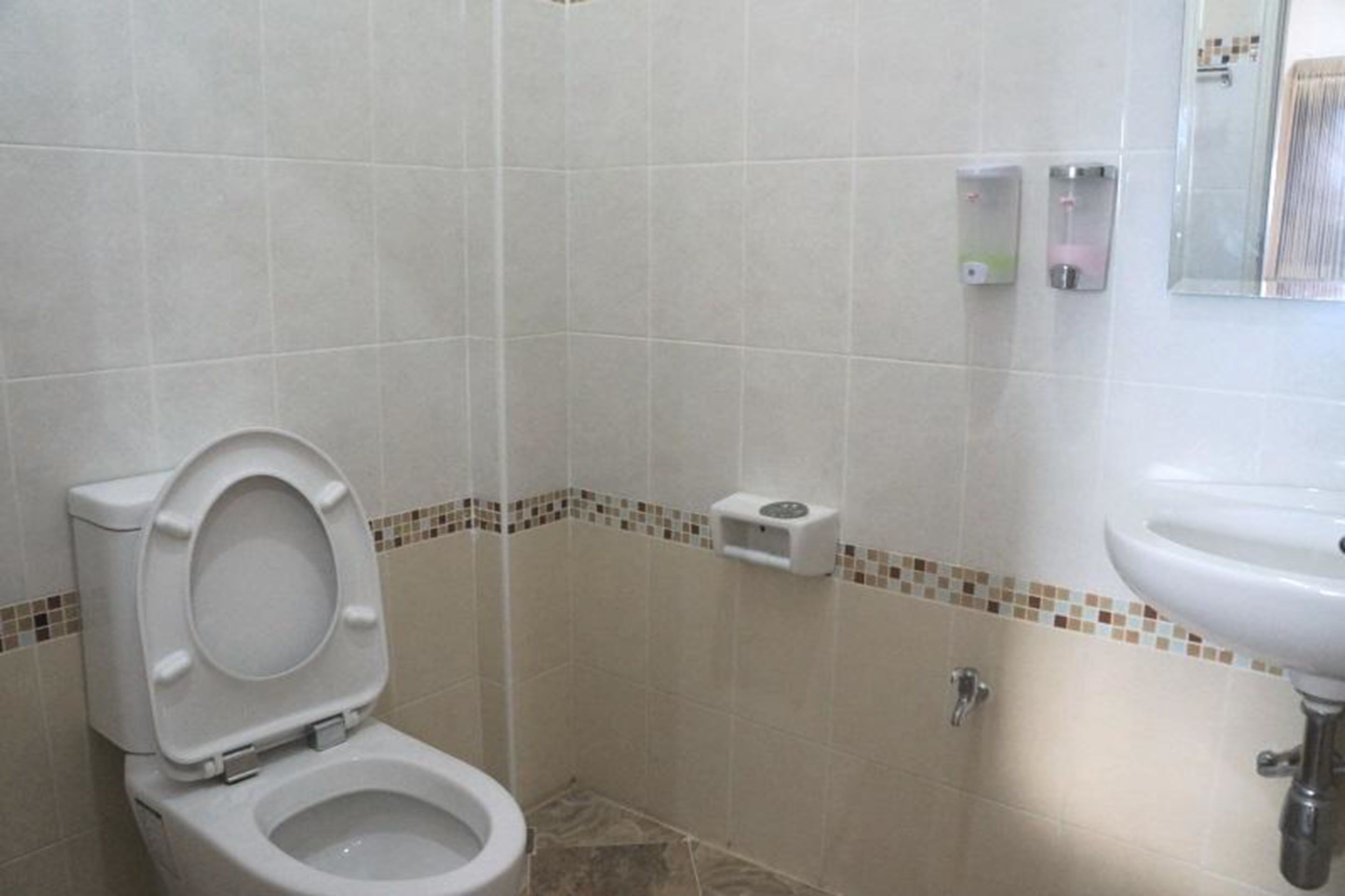 Un baño con inodoro, lavamanos y zona de ducha.