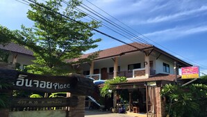 Un edificio con un cartel que dice "Suan Luang Place" y una escalera que lleva a un balcón.