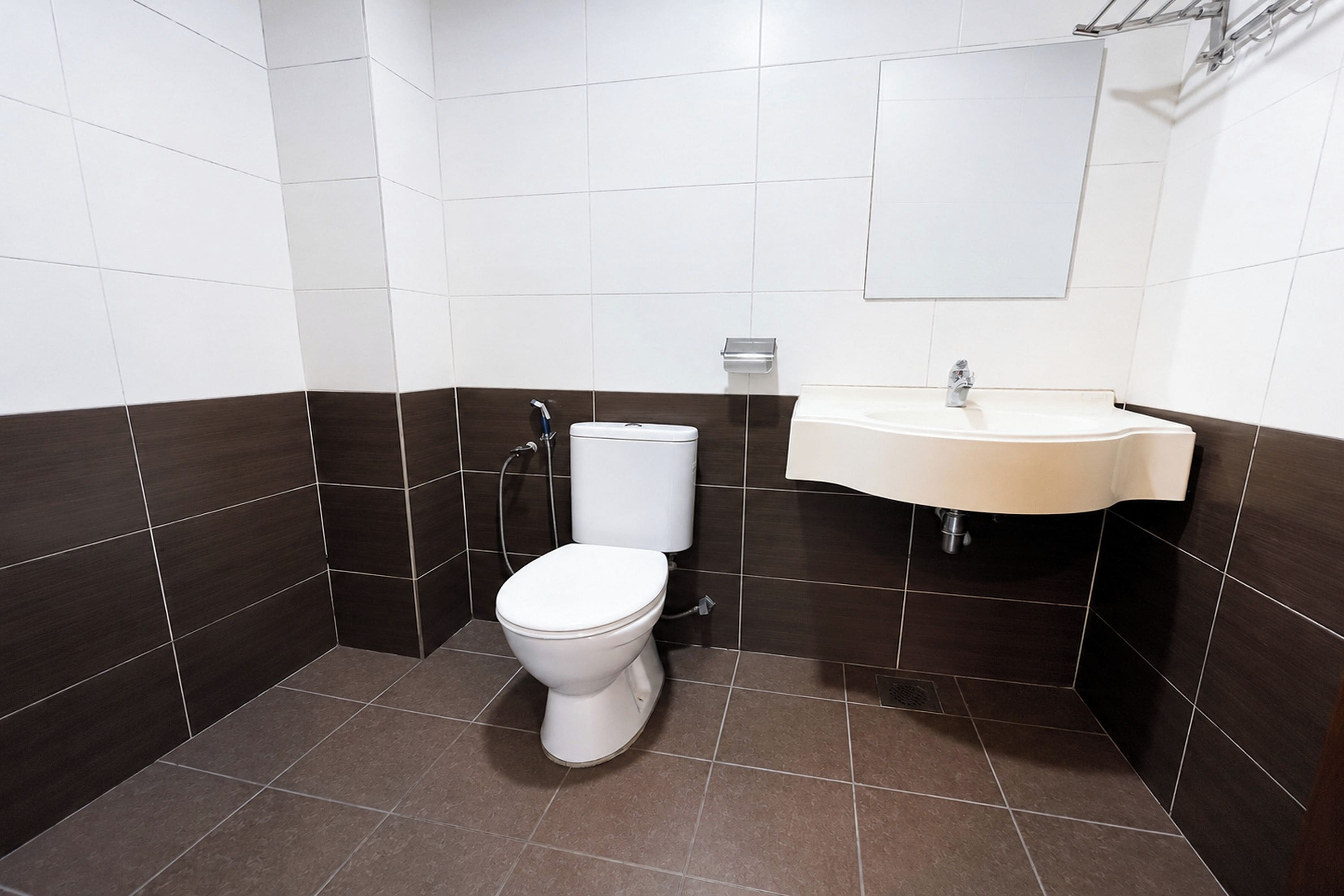 A small, modern bathroom with a toilet, sink, and mirror.