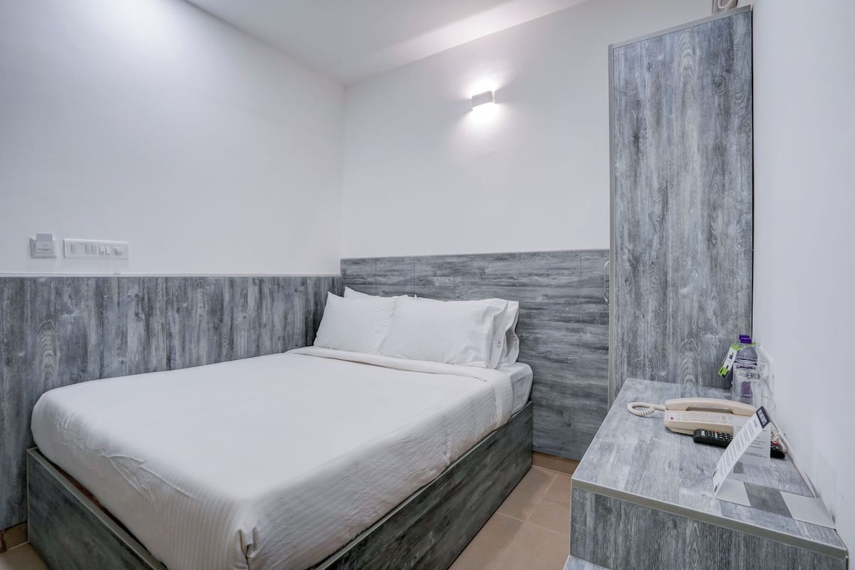 A bedroom with a bed, bedside table, and a telephone.