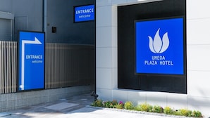 The entrance to the Umeda Plaza Hotel with a clear directional sign and a welcome sign.