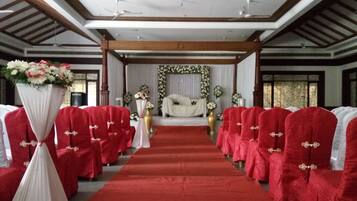 Un pasillo de alfombra roja que conduce a un escenario con decoraciones florales.