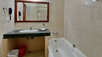 Un baño con lavabo, espejo y bañera.