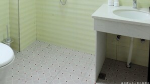 Een badkamer met douche, toilet en wastafel.