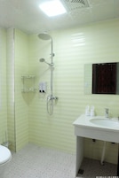 A bathroom with a shower, toilet, and sink.
