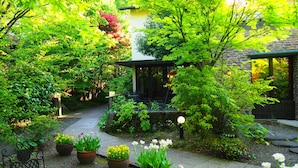 A garden with a stone pathway, potted plants, and a gazebo. - Yufuin Onsen Ryokan Hananomai (Yufu)