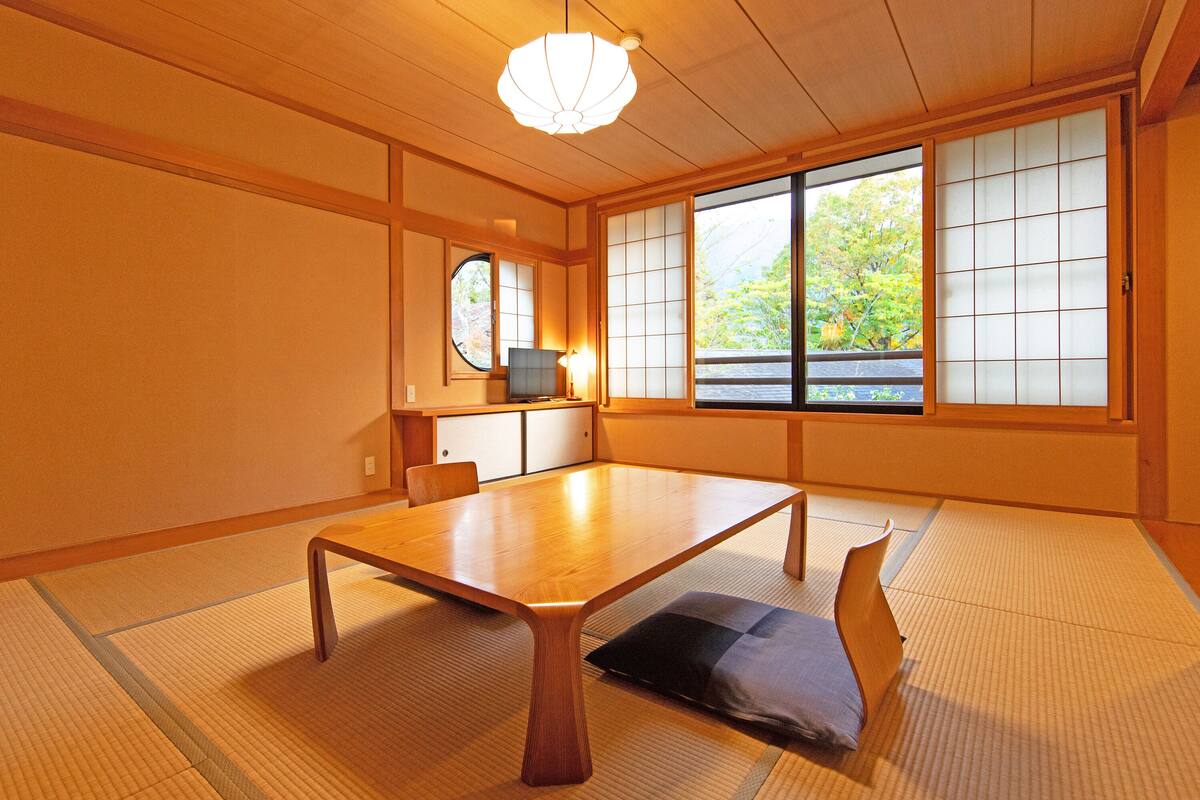 A traditional Japanese room with tatami flooring, a low table, and sliding shoji doors.