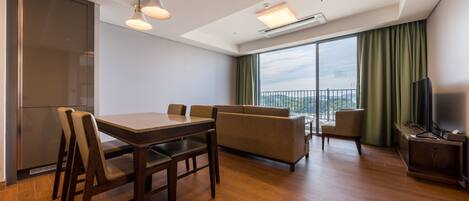 A modern living room with a dining area, a sofa, a TV, and a balcony with a view.