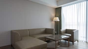 Una habitación de hotel moderna con un sofá modular, una mesita y una lámpara.